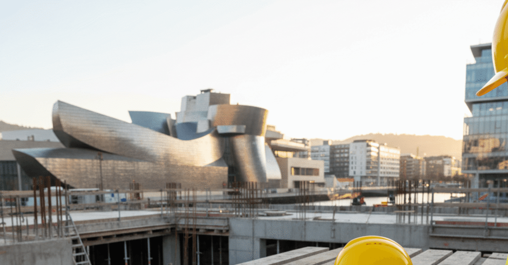 Hombre consultando planos de construcción en una obra en Bilbao, gestionando los permisos reforma piso bilbao.